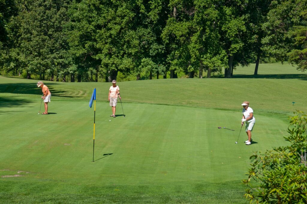 People putting on a golf course green