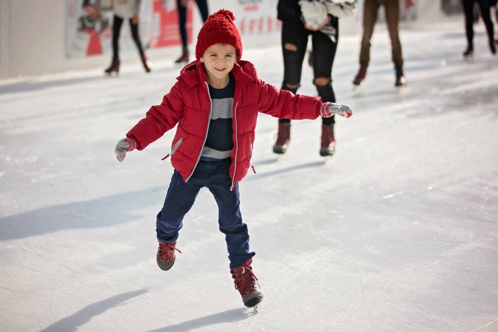 young boy ice skating on ice rink