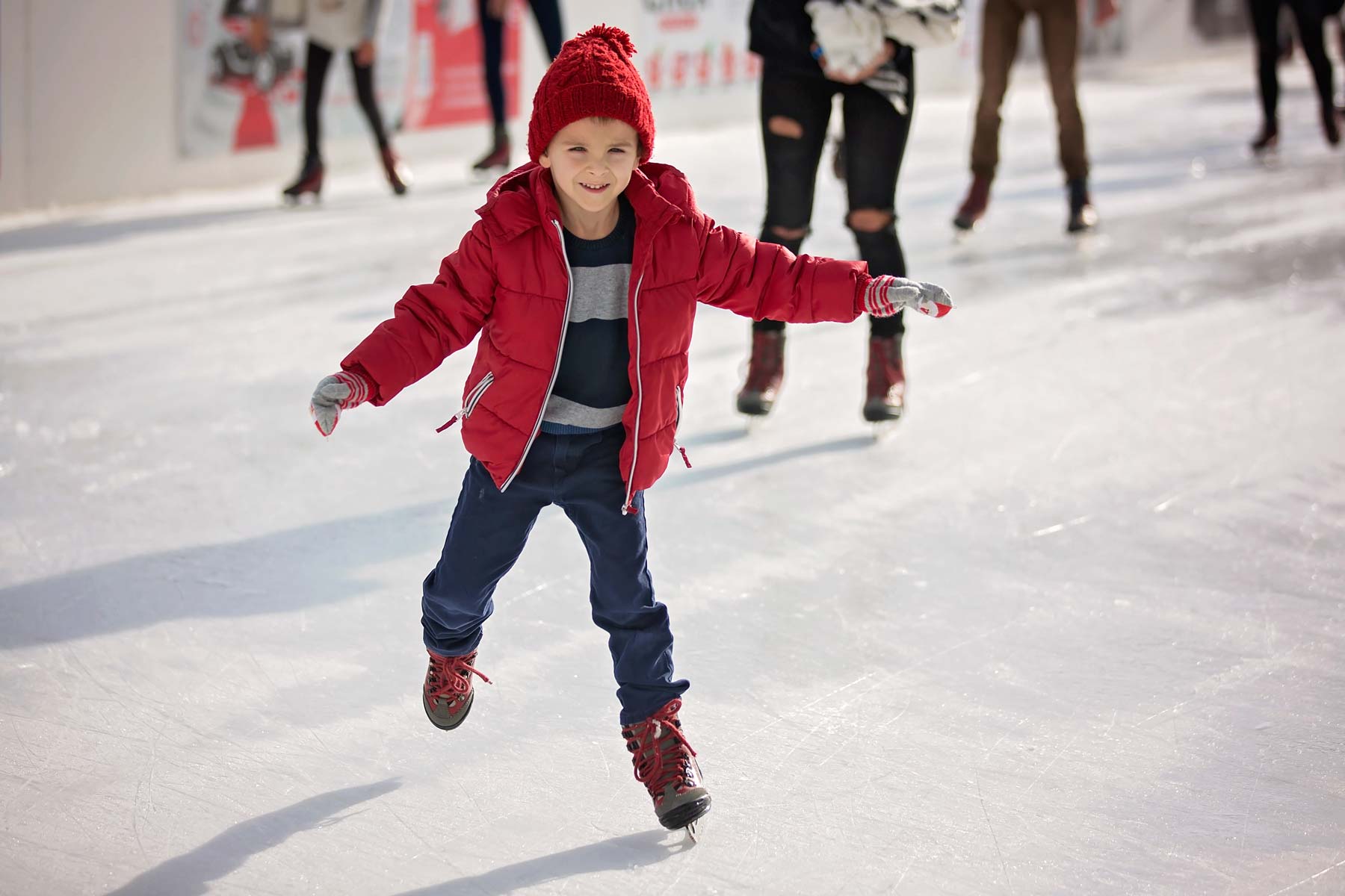 young boy ice skating on ice rink