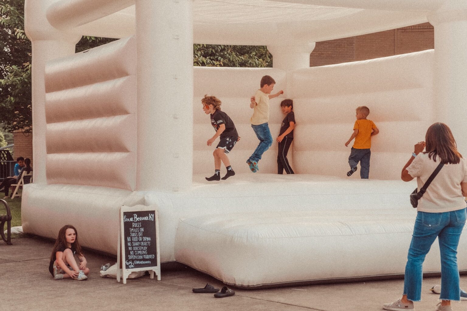 Kids jump in a large white inflatable